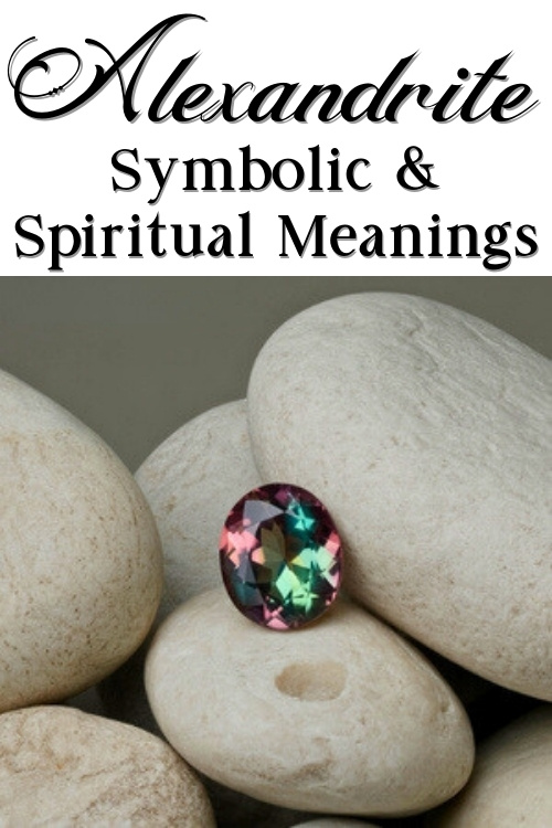 A colorful alexandrite gem rests on smooth white stones. Above, text reads "Alexandrite Symbolic & Spiritual Meanings" in elegant, bold font.