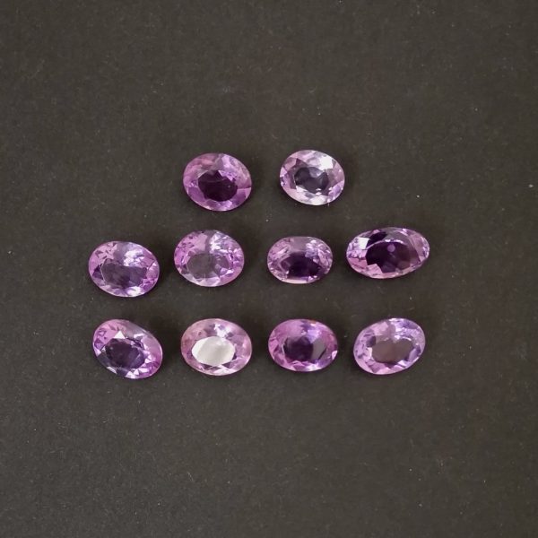The set of 10 purple amethyst ovals are displayed on a black background