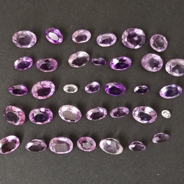 The bundle of 34 amethyst ovals displayed on a black background