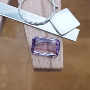 The purple amethyst rectangle displayed on a jewellers bench peg with some sterling silver sheet and wire.