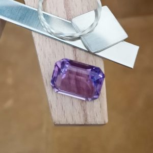 The purple amethyst rectangle displayed on a jewellers bench peg with some sterling silver sheet and wire.