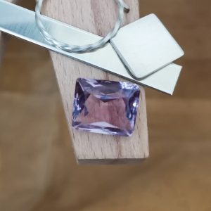The purple amethyst rectangle displayed on a jewellers bench peg with some sterling silver sheet and wire.