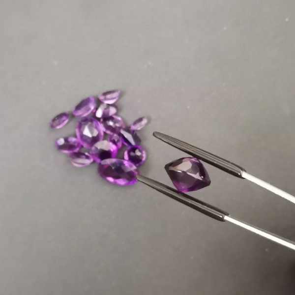 A photo of one of the amethyst gemstones showing it from a side view as it's an unusual shape, having a point on both the top and bottom.