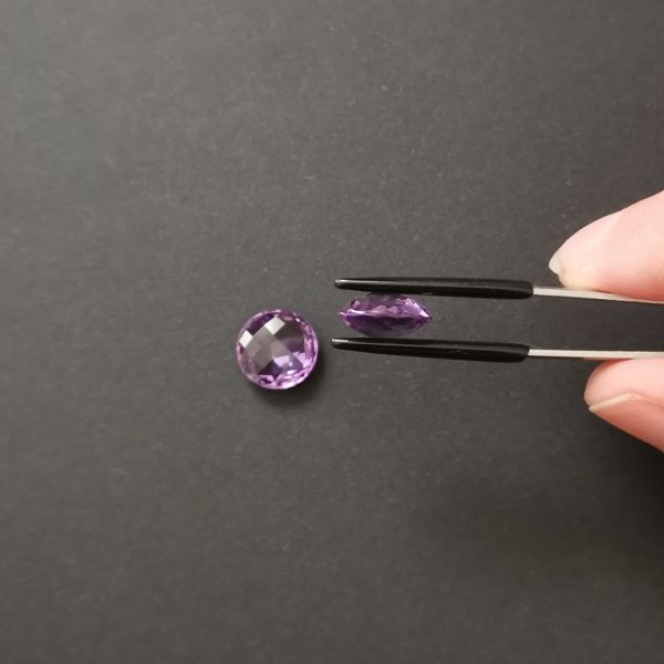 a photo of the gems side view showing the shape is more of a puffy coin.