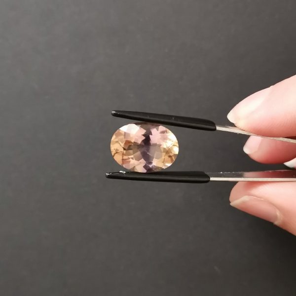 A photo of the crown area of the purple and yellow ametrine against a black background