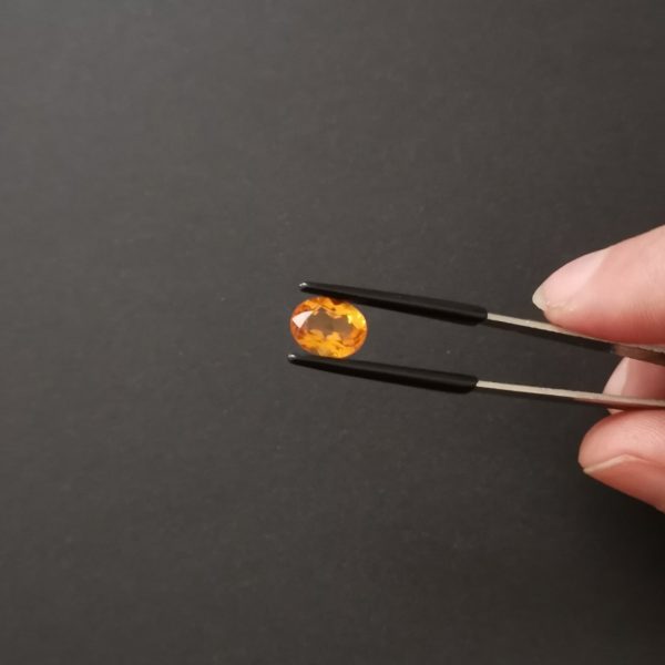 A photo of the crown area of the orange citrine against a black background
