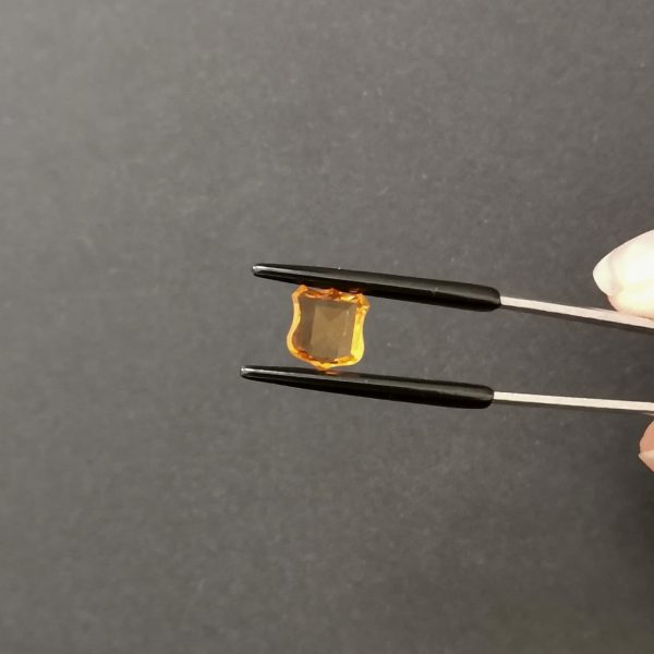 A photo of the crown area of the orange citrine against a black background