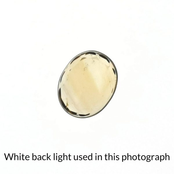 The golden yello citrine oval gem is being back-lit with a bright white light to show any inclusions within the gem more clearly.