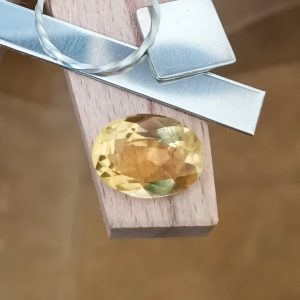 The yellow citrine oval displayed on a jewellers bench peg with some sterling silver sheet and wire.