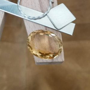 The yellow citrine oval displayed on a jewellers bench peg with some sterling silver sheet and wire.