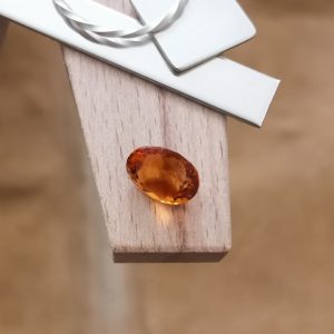 The orange citrine oval displayed on a jewellers bench peg with some sterling silver sheet and wire.