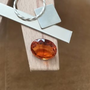 The mandarin citrine oval displayed on a jewellers bench peg with some sterling silver sheet and wire.