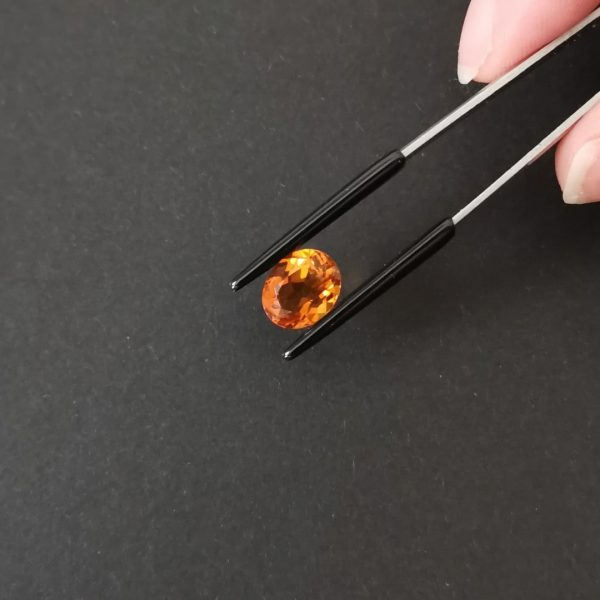 A photo of the crown area of the orange citrine against a black background