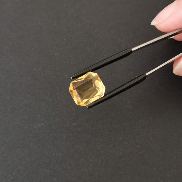 A photo of the crown area of the golden yellow citrine against a black background