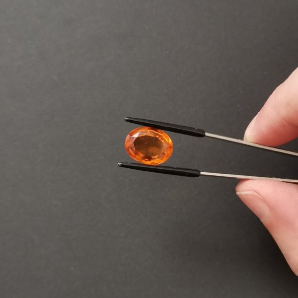 A photo of the crown area of the mandarin orange citrine against a black background