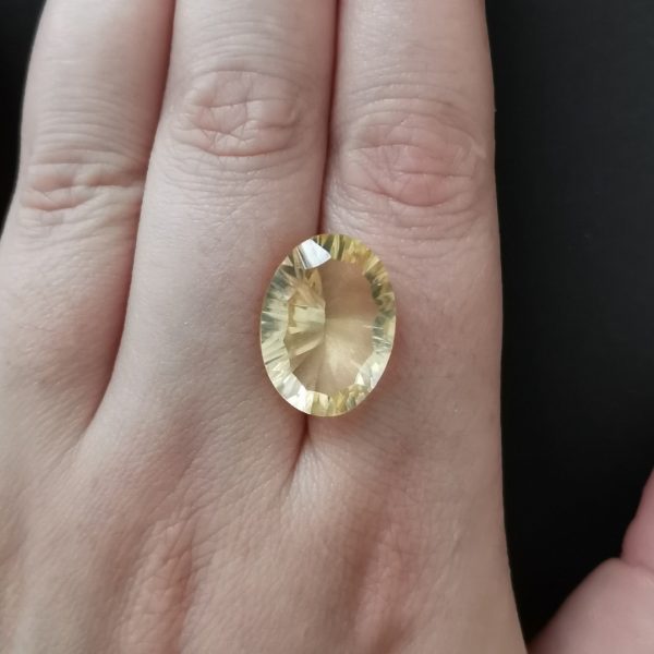 The yellow citrine gemstone resting on a hand to give an idea of the gemstone size and colour.