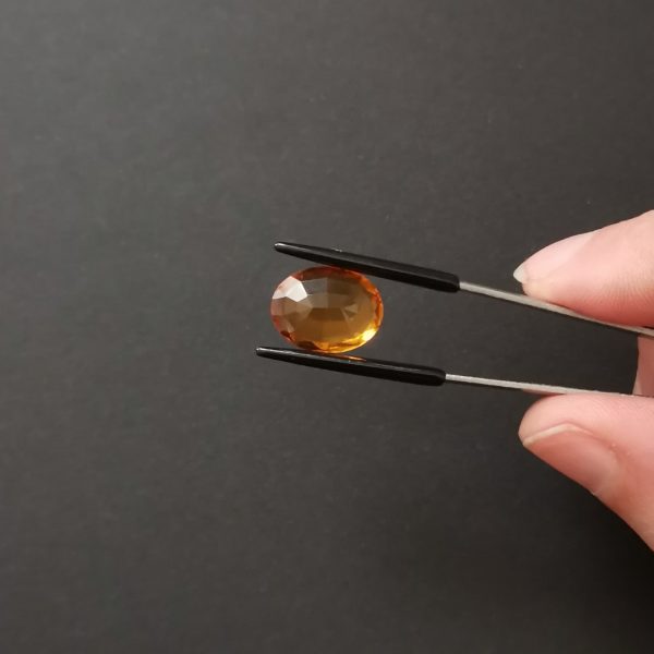 a photo of the pavilion of the orange citrine oval against a black background