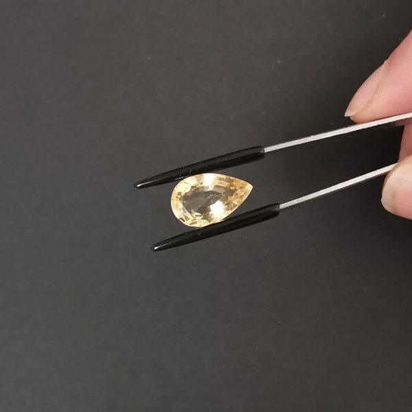 A photo of the crown area of the golden yellow citrine against a black background