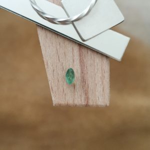 The green emerald marquise displayed on a jewellers bench peg with some sterling silver sheet and wire.
