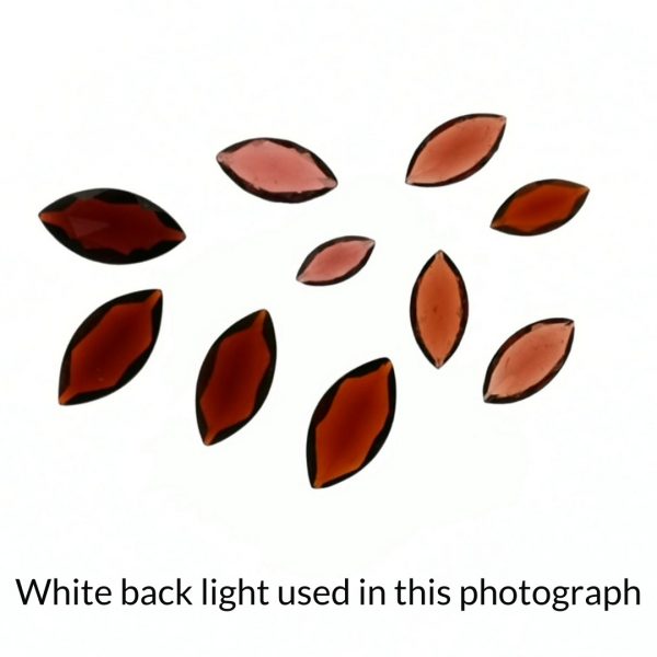 The red garnet gems are being back-lit with a bright white light to show any inclusions within the gem more clearly.