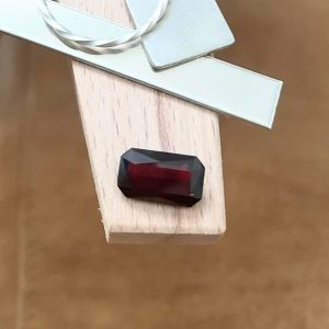 The red garnet rectangle displayed on a jewellers bench peg with some sterling silver sheet and wire.