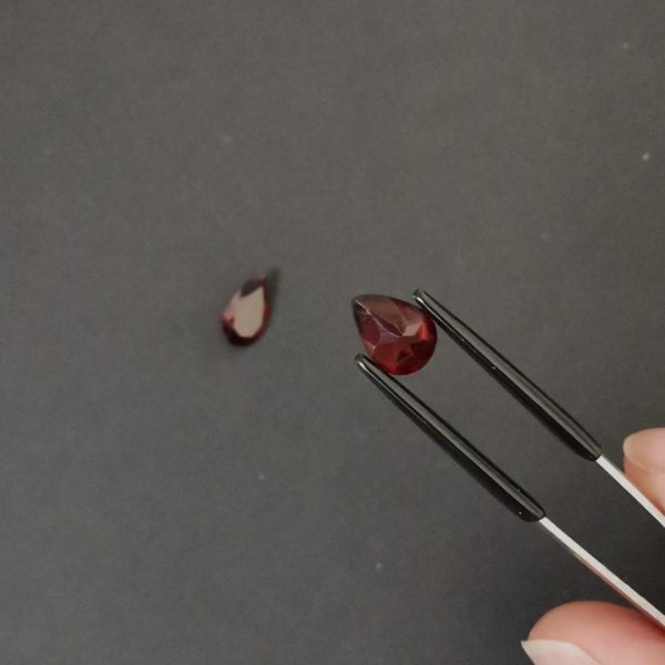 a photo of the pavilion of the red garnet teardrops against a black background