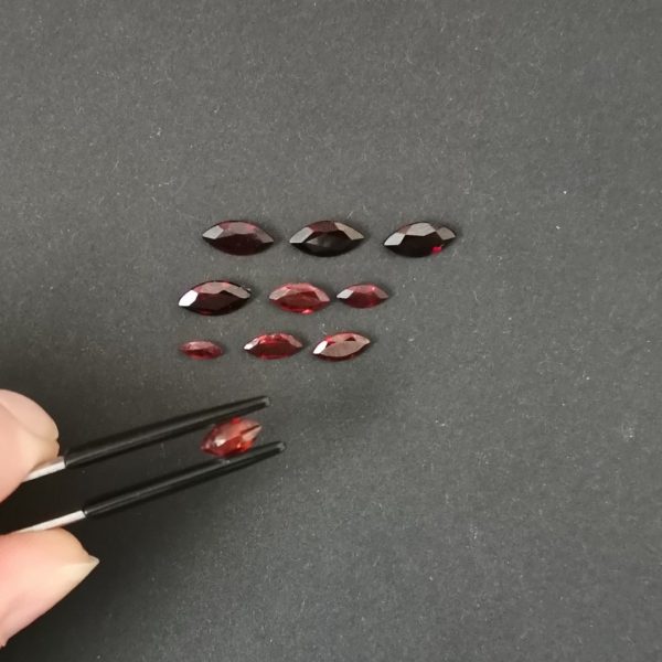 a photo of the pavilion of the red garnet marquise gems against a black background