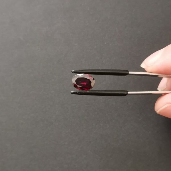 A photo of the crown area of the purple-red garnet against a black background
