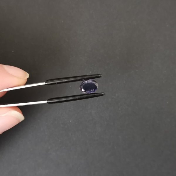 A photo of the crown area of the purple iolite against a black background