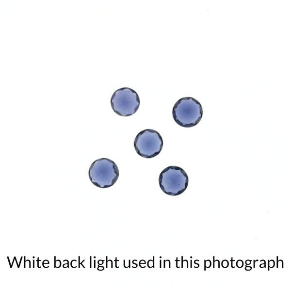The set of iolite gems is being back-lit with a bright white light to show any inclusions within the gems more clearly.