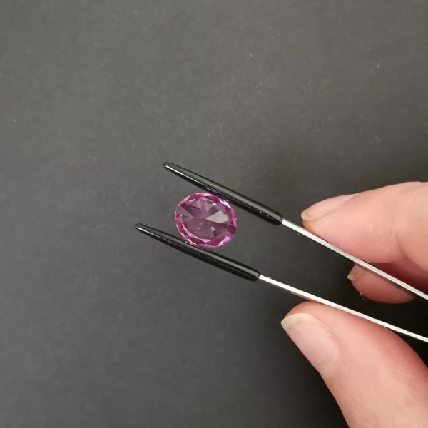 a photo of the pavilion of the lab grown purple sapphire oval against a black background