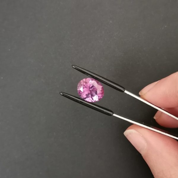 A photo of the crown area of the purple lab grown sapphire against a black background