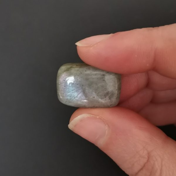 A photo of the crown area of the labradorite cabochon showing it's subtle shimmer against a black background