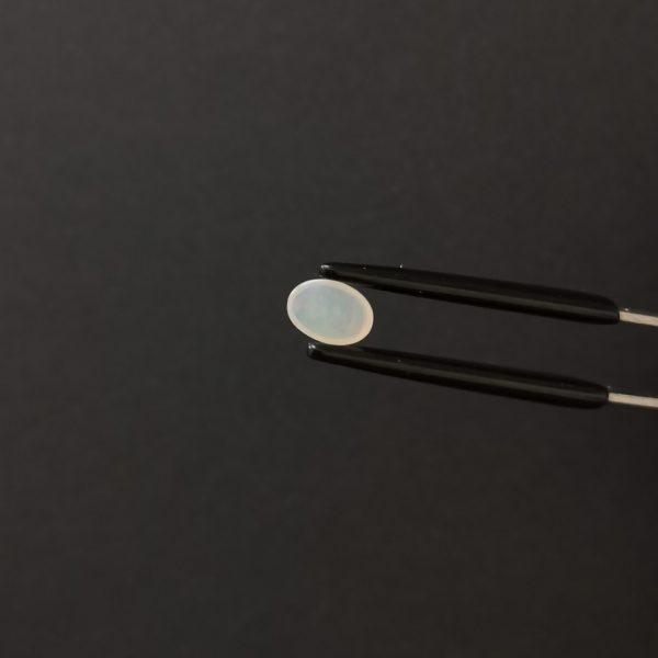 a photo of the pavilion of the opal cabochon oval against a black background