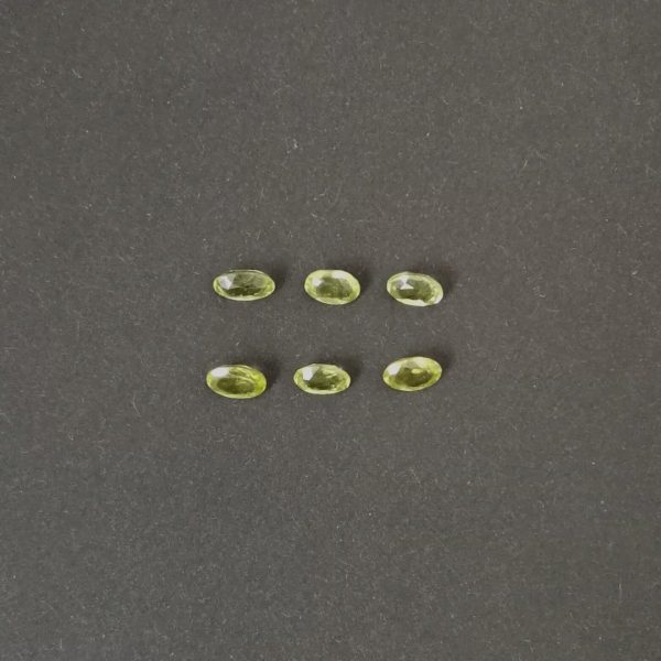 the set of 6 green peridot ovals shown on a black background