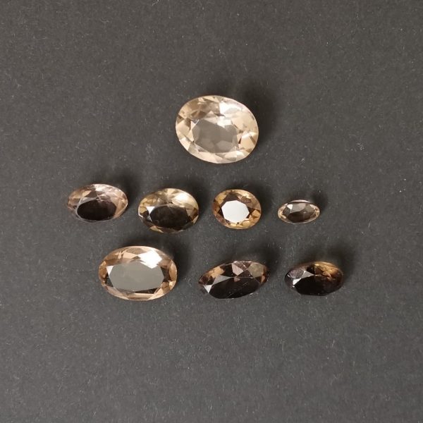 the set of 8 smoky quarts ovals displayed on a black background