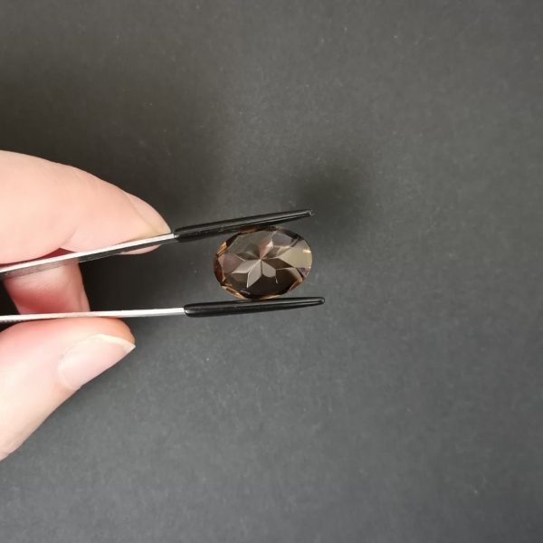 a photo of the pavilion of the brown smoky quartz oval against a black background