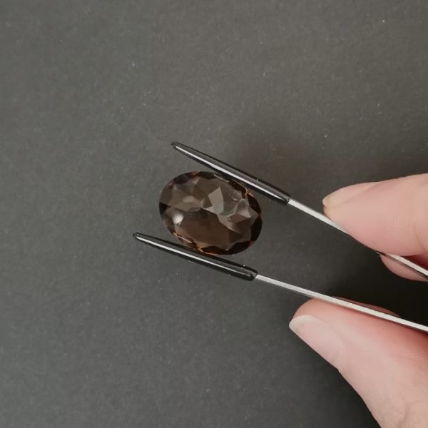 a photo of the pavilion of the brown smoky quartz oval against a black background