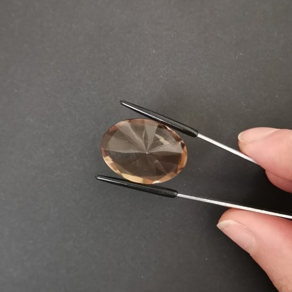 a photo of the pavilion of the brown smoky quartz oval against a black background
