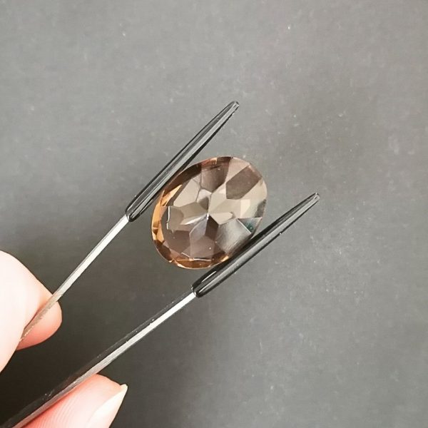 a photo of the pavilion of the brown smoky quartz oval against a black background