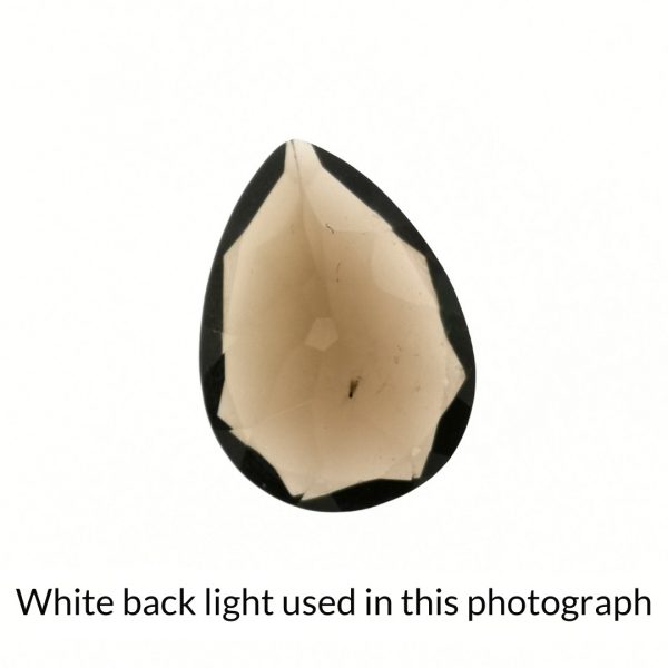 The brown smoky quartz teardrop gem is being back-lit with a bright white light to show any inclusions within the gem more clearly.