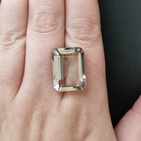 The smoky quartz gemstone resting on a hand to give an idea of the gemstone size and colour.