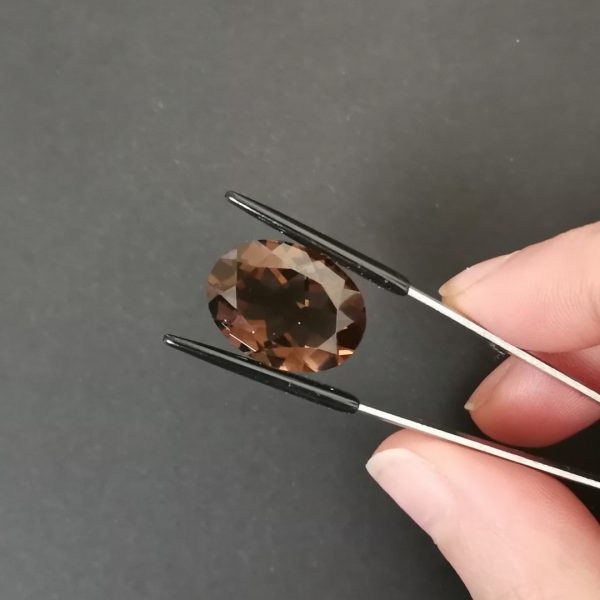 A photo of the crown area of the rich brown smoky quartz against a black background