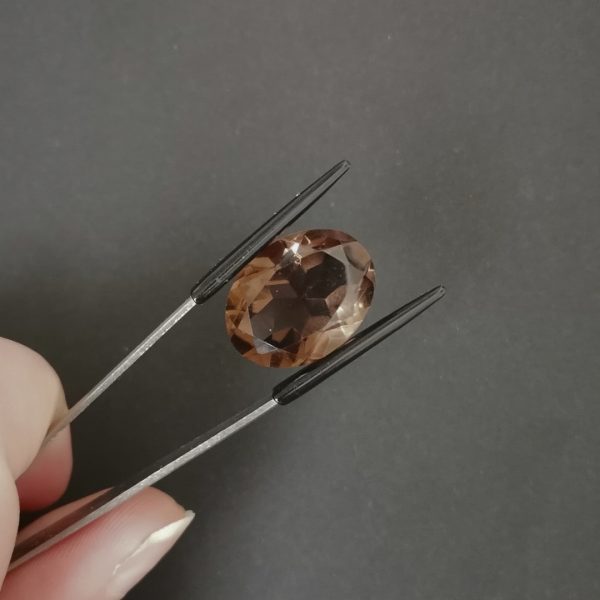 A photo of the crown area of the rich brown smoky quartz against a black background