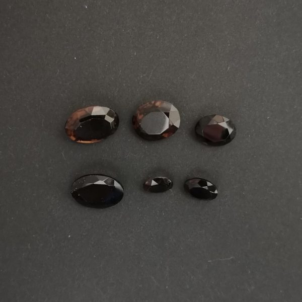 The set of 6 dark brown smoky quartz ovals displayed on a black background