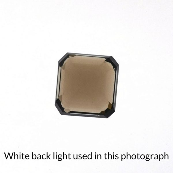 The brown smoky quartz square gem is being back-lit with a bright white light to show any inclusions within the gem more clearly.