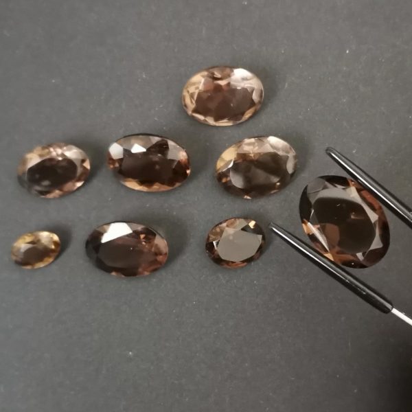 A photo of the crown area of the brown smoky quartz ovals against a black background
