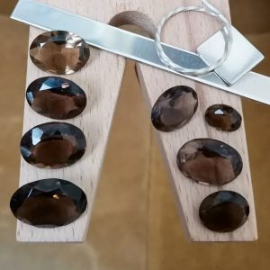 The brown smoky quartz oval bundle displayed on a jewellers bench peg with some sterling silver sheet and wire.