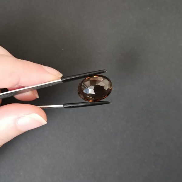 a photo of the pavilion of the brown smokey quartz oval against a black background