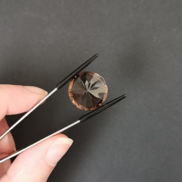 a photo of the pavilion of the dark brown smoky quartz round against a black background